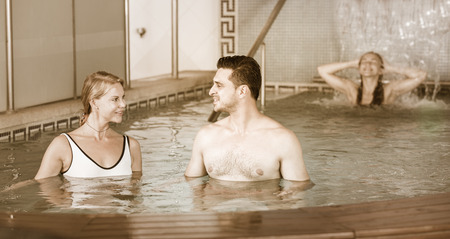 Two happy cheerful  friends are resting in pool in time spa-day in salon.の写真素材