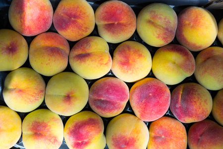 Image of peaches in boxes outdoor.