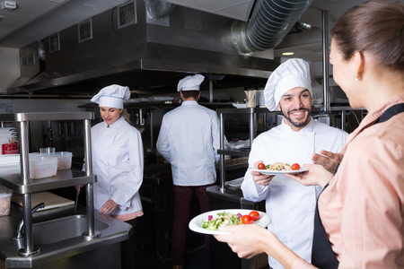 Head chef checking dishes in kitchen of restaurant before serving guestsの写真素材