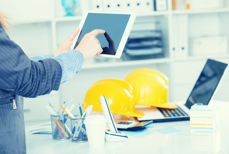 Business woman holding and using tablet at workplace in officeの写真素材