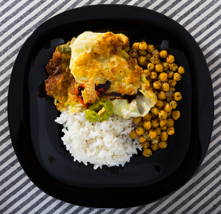 Image of chicken thighs with cabbage leaves in batter, cheakpea and rice at plateの写真素材