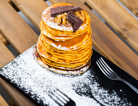 Delicate fried fritters with pieces of chocolate and walnut sprinkled with sugar powderの写真素材