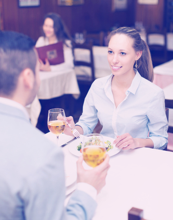 Young pretty woman having romantic dinner with guy in restaurantの写真素材