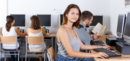 Portrait of young female student working on computer in university libraryの写真素材