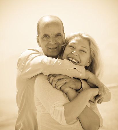 Happy tourist couple at sea beach on holiday smiling and hugの写真素材