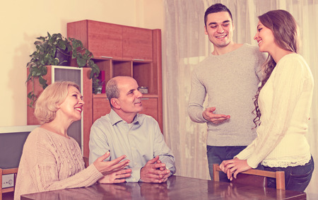 Happy young man showing his future wife to smiling parentsの写真素材