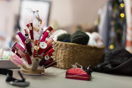 Workplace with spool of threads in sewing shop of variety clothes factoryの写真素材