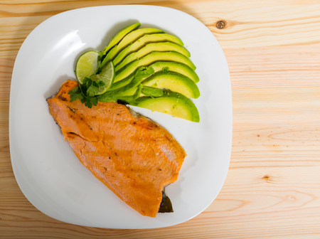 Photography of plate with fried trout fillet with avocado in restaurante.の写真素材