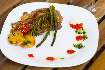 Image of veal with baked vegetables on the plate indoors.の写真素材