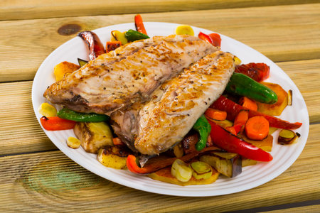 Dish of Bulgarian cuisine â€“ grilled vegetables with fried scomber served on plate