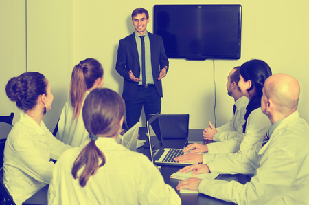 Cheerful positive manager making speech during business meeting in officeの写真素材