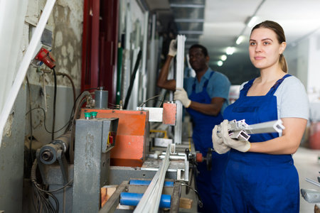 Portrait of woman worker who is occupation near special machine in the pvc workshop.