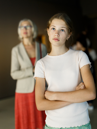 Attentive teenage girl exploring artworks in modern museumの写真素材