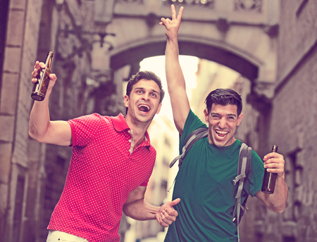 Portrait of two smilling football fans with beer who are celebrate win of teem in matcn at the Barcelonaの写真素材
