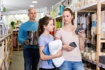 Loving  smiling parents and happy girl shopping for bathroom accessories at store of home decorの写真素材