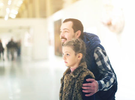 Young father and little daughter looking at expositions in museumの写真素材