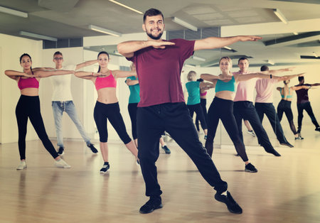 Group of active young people dancing in dance studio