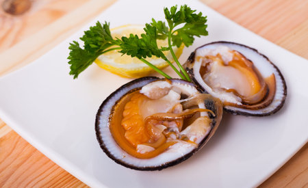 Fresh bivalve mussels (glycymeris) served with lemon on plate
