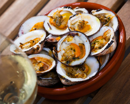 Dish of Mediterranean cuisine - tasty baked Dog cockles (bivalve mollusks) served in bowl