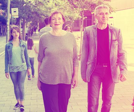 Smiling couple of mature male and female walking on holidayの写真素材