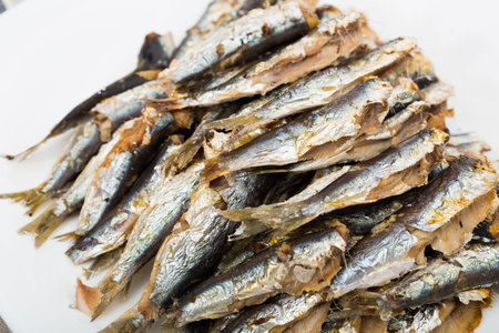 Seafood. Appetizing baked sardines served without garnish on white plate