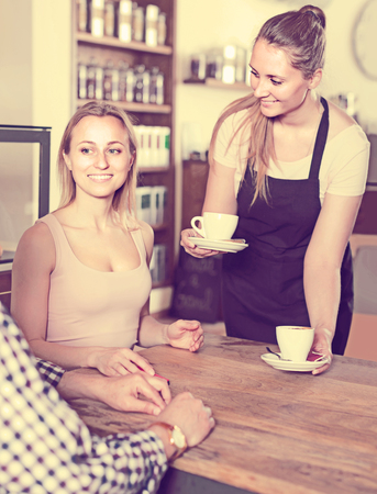 happy middle aged man and young woman talking in cozy cafeの写真素材