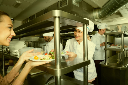 Chef of restaurant with team of cooks busy to preparing food for they clientの写真素材