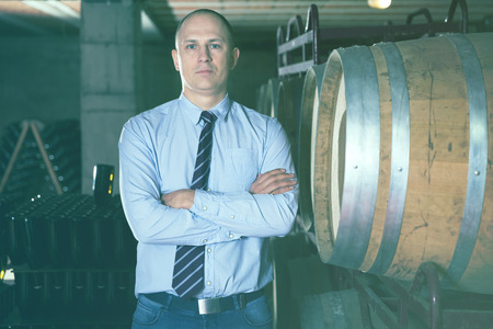 Portrait of professional male winemaker standing in wine cellarの写真素材