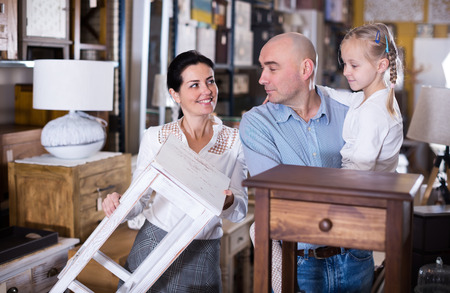 family is considering the options curbstone for bedroom in the furniture store.の写真素材