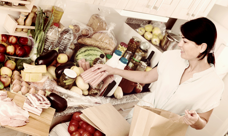 Portrait of cheerful italian woman who is readying for cooking new recipe at home.の写真素材