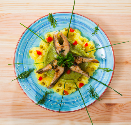Deliciously fried trout steaks with mashed potatoes,  guacamole and greens on plateの写真素材