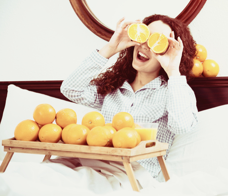 Portrait of brunette with sweet oranges and juice in trayの写真素材