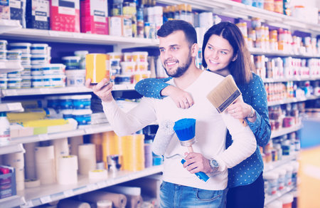 Young loving couple choosing materials for house decoration in paint supplies shopの写真素材