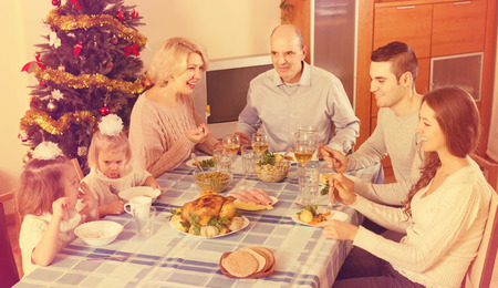 Celebration of christmas in the bosom of smiling family at the table at homeの写真素材