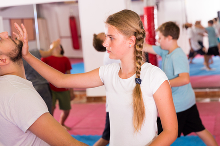 Mixed age group at self protection workout, training attack movements in pairsの写真素材