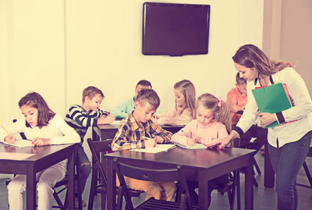 Professor and elementary age children at a classroom in school