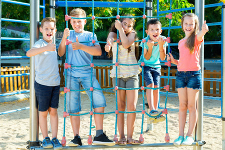 Five  glad kids posing  at the playground together