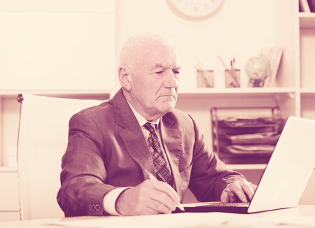 Smiling man worker working effectively on project in officeの写真素材