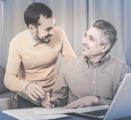 Young man and sales manager discuss terms of contract of purchase at homeの写真素材