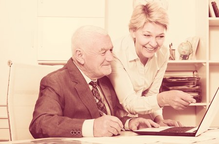 Aged manager and secretary working productively together in officeの写真素材