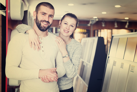Portrait of couple looking  kitchen ceramic tile  in shopの写真素材