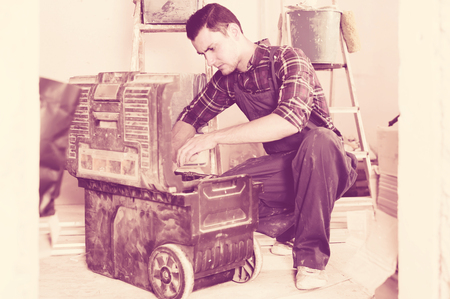 professional builder handyman choosing necessary tool in toolboxの写真素材