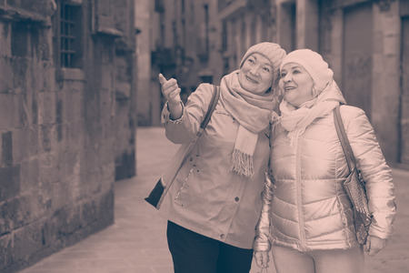Happy elderly women enjoying walk around town during join travelの写真素材