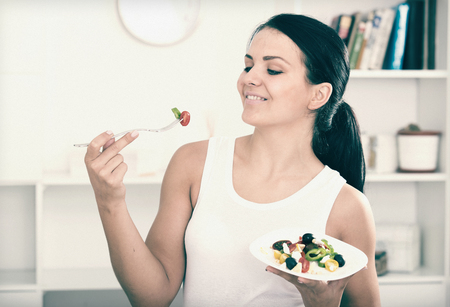 Brunette girl holding plate of vegetable saladの写真素材