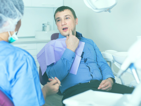 professional positive doctor woman talking with patient in medical chairの写真素材