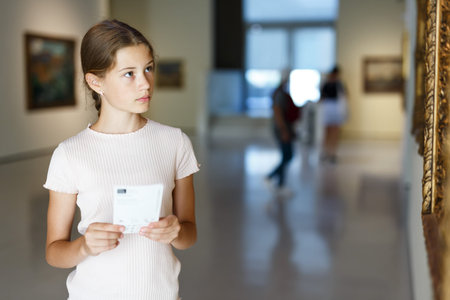 Portrait of tweenage girl looking at exposition in historical museum