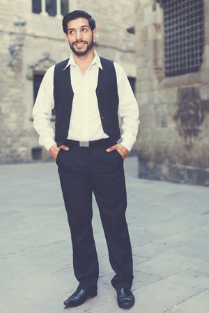 Full-length portrait of handsome man standing at ancient streetの写真素材