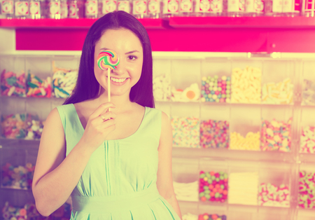 Portrait of  girl  with lollypop at candies shopの写真素材
