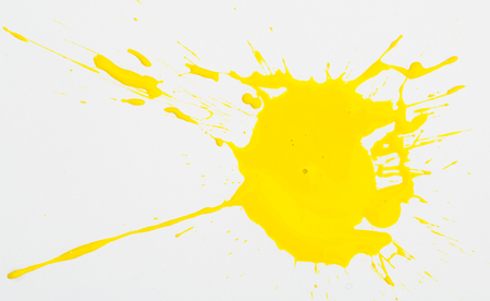 Spilled yellow paint spots on paper, colorfull artistic image on white backgroundの写真素材