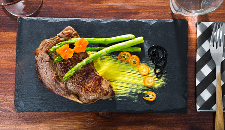 Grilled well done beef steak with asparagus and avocado sauceの写真素材